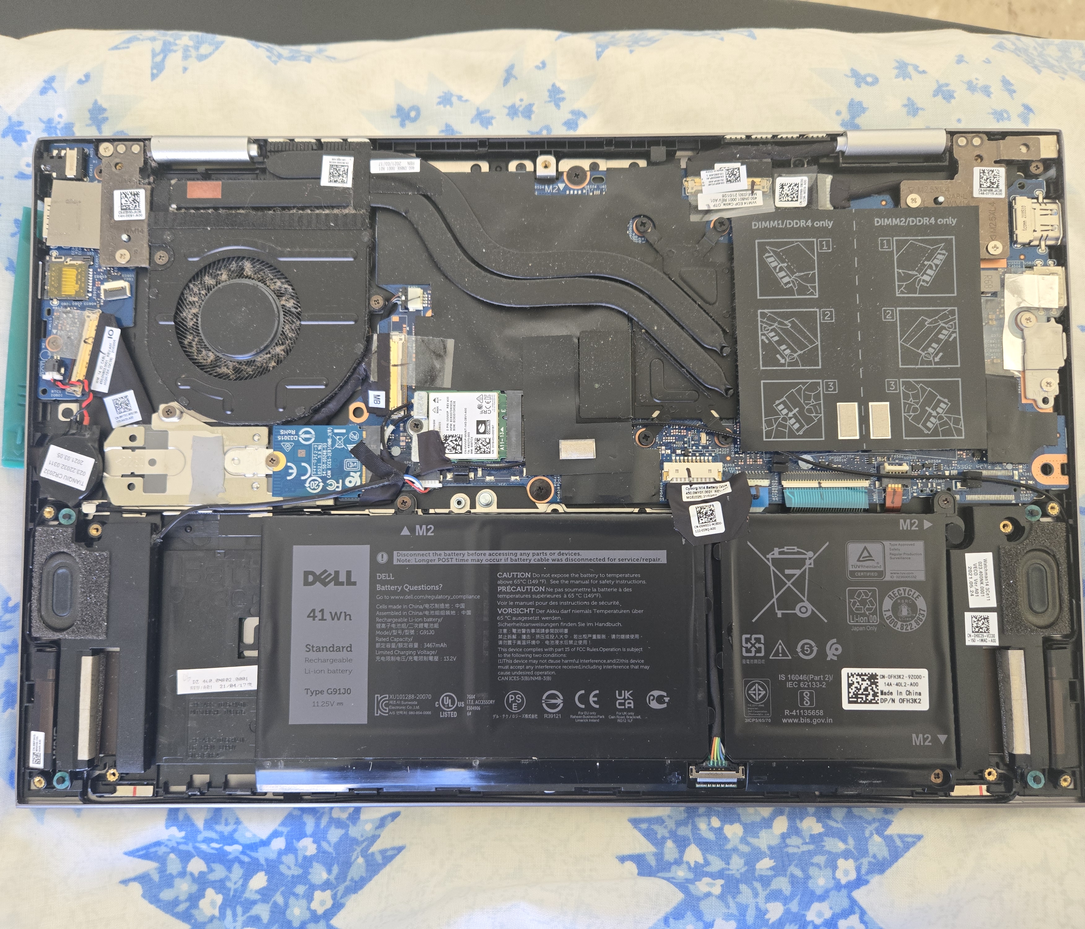 Interior del Dell Inspiron 14 2-in-1 con tapa trasera removida mostrando batería Dell 41Wh, ventilador y componentes internos